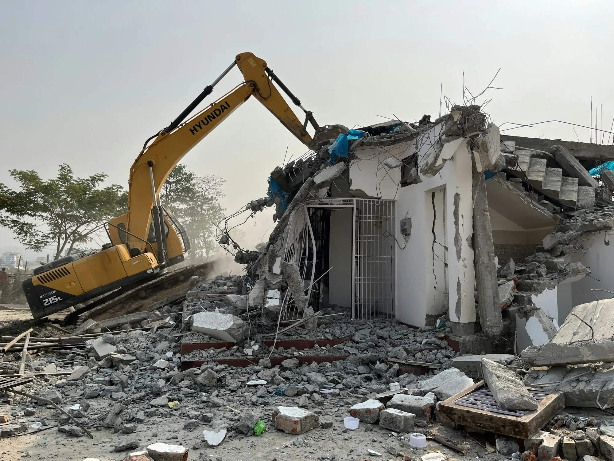 Excavator demolishing a small building